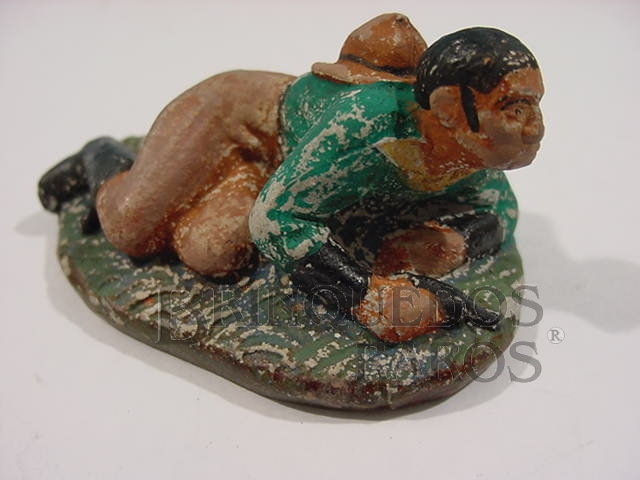 Brinquedo antigo Cowboy agachado com revolver Papier Maché Década de 1940 
