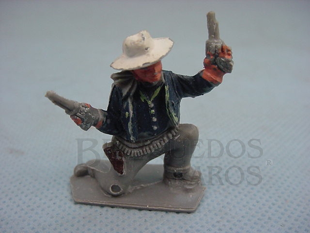 Brinquedo antigo Cowboy ajoelhado com dois revolveres Década de 1960
