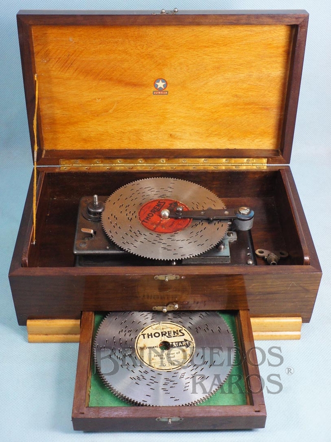 Brinquedo antigo Caixa de música com Discos perfurados intercambiáveis com diversas melodias Base medindo 21,00 x 17,00 cm Logotipo Estrella Mecanismo Thorens Suíço Ano 1945