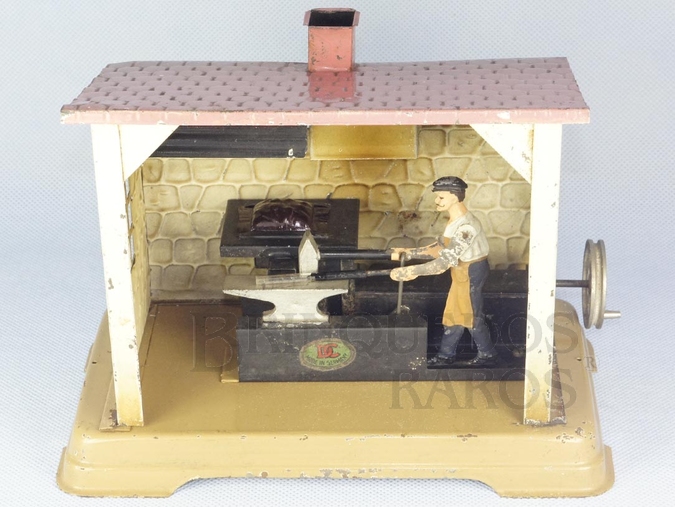 Brinquedo antigo Ferreiro martelando na Bigorna com 17,00 cm de comprimento fabricado pela fábrica Doll, Alemanha em lata litografada. Brinquedo movido por uma Caldeira à Vapor. Década de 1920.