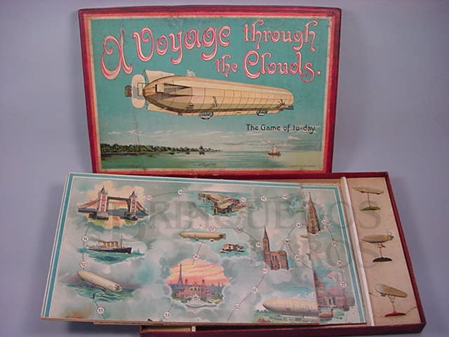 Brinquedo antigo Jogo de Tabuleiro A Voyage Througt The Clouds The Game of To Day produzido pela Fábrica J.W. Spear and Sons na Inglaterra em papel e cartão Apresenta seis Dirigíveis de chumbo de 6,00 cm de comprimento Década de 1920